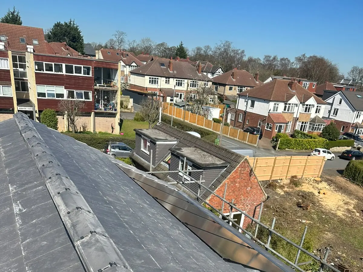 Looking along the ridge of a newly tiled roof with scaffolding at the eaves