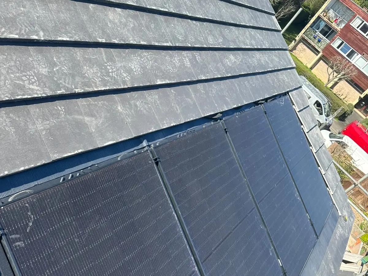 Interlocking roof tiles laid around in-roof solar panels